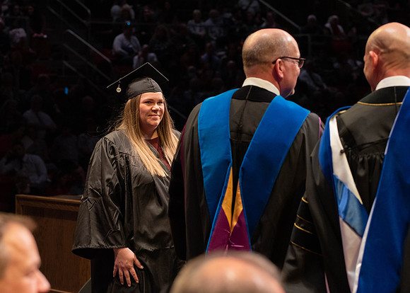 Students graduate and walk to receive their diplomas during convocation in the College of Physical Sciences and Engineering.