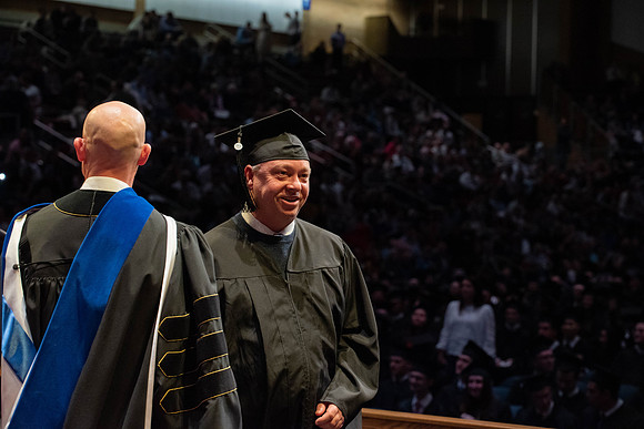 Students graduate and walk to receive their diplomas during convocation in the College of Physical Sciences and Engineering.