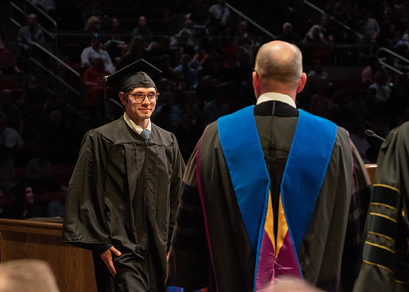 Students graduate and walk to receive their diplomas during convocation in the College of Physical Sciences and Engineering.
