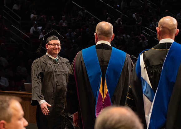 Students graduate and walk to receive their diplomas during convocation in the College of Physical Sciences and Engineering.