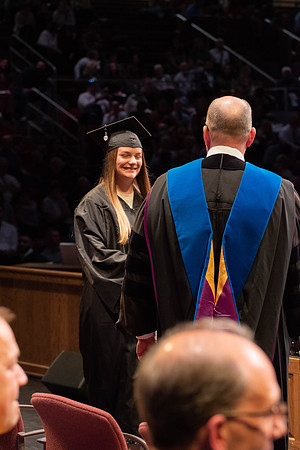 Students graduate and walk to receive their diplomas during convocation in the College of Physical Sciences and Engineering.