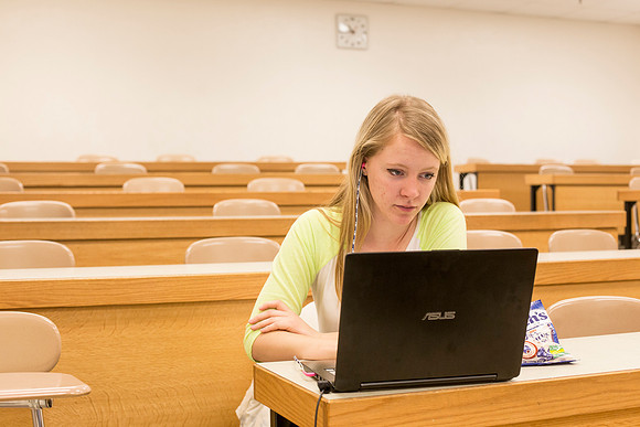 Eliza Shumway, a Junior majoring in Biology studies in an empty classroom.