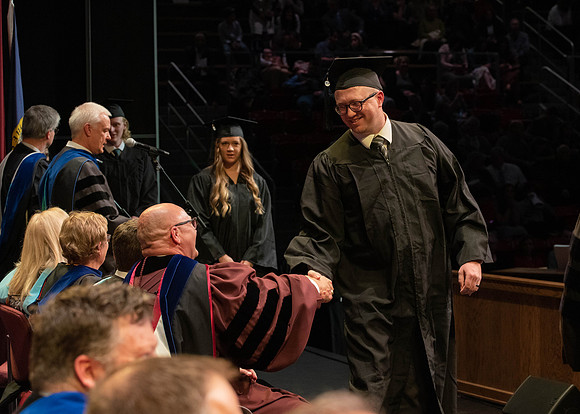 Students graduate and walk to receive their diplomas during convocation in the College of Physical Sciences and Engineering.