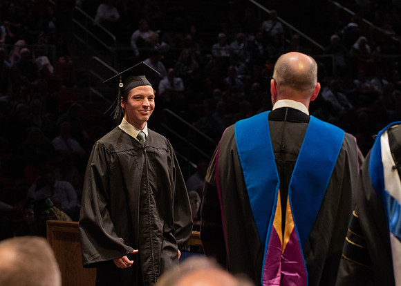 Students graduate and walk to receive their diplomas during convocation in the College of Physical Sciences and Engineering.