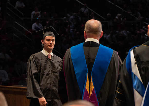 Students graduate and walk to receive their diplomas during convocation in the College of Physical Sciences and Engineering.