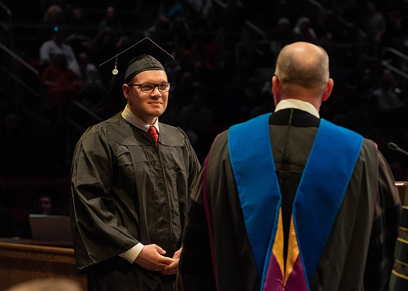 Students graduate and walk to receive their diplomas during convocation in the College of Physical Sciences and Engineering.
