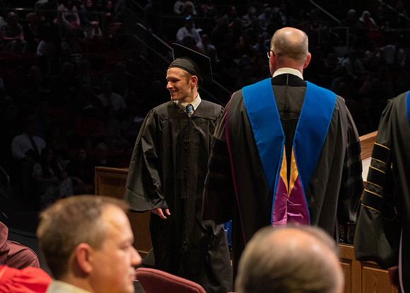 Students graduate and walk to receive their diplomas during convocation in the College of Physical Sciences and Engineering.