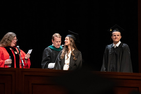 Students graduate and walk to recieve their diplomas during convocation in the College of Business and Communications.