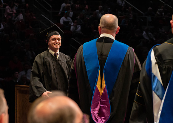 Students graduate and walk to receive their diplomas during convocation in the College of Physical Sciences and Engineering.