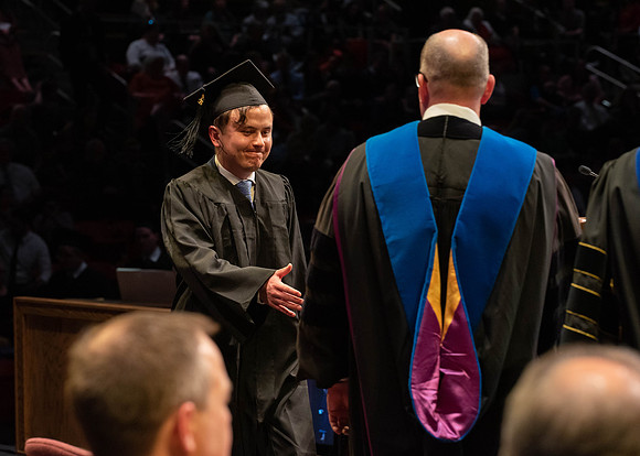 Students graduate and walk to receive their diplomas during convocation in the College of Physical Sciences and Engineering.