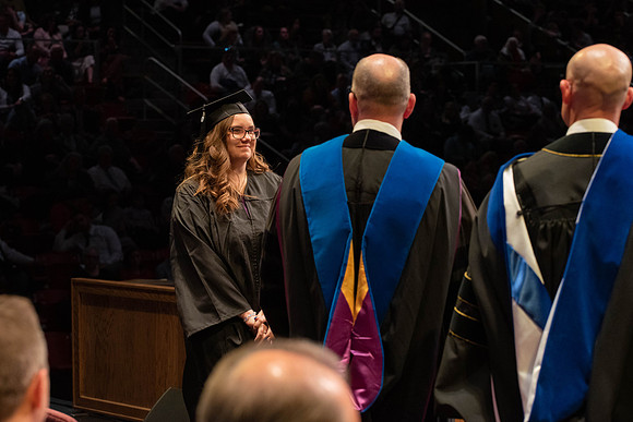 Students graduate and walk to receive their diplomas during convocation in the College of Physical Sciences and Engineering.