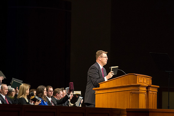 President Gilbert holds up his scriptures and asks if students, "Are you ready to be taught?"