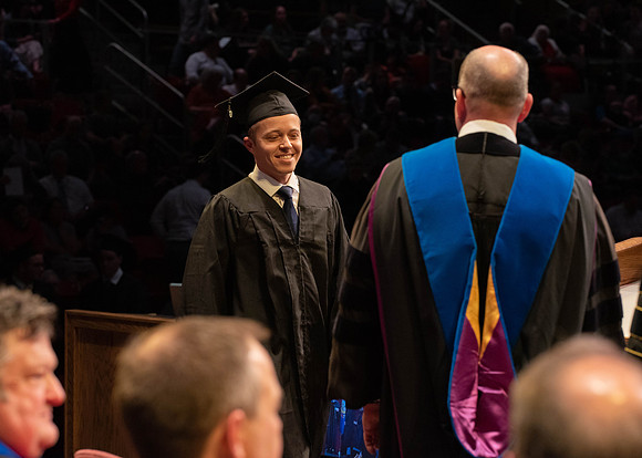 Students graduate and walk to receive their diplomas during convocation in the College of Physical Sciences and Engineering.