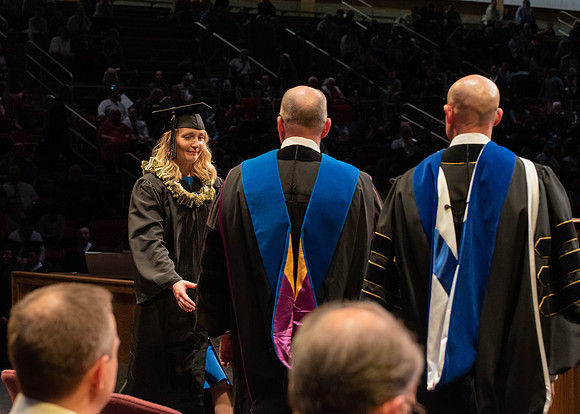 Students graduate and walk to receive their diplomas during convocation in the College of Physical Sciences and Engineering.