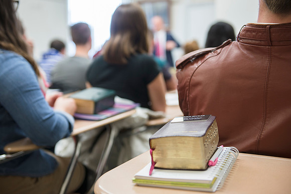 Student brings scriptures used from serving a mission in a religion class.