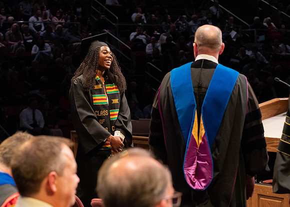 Students graduate and walk to receive their diplomas during convocation in the College of Physical Sciences and Engineering.
