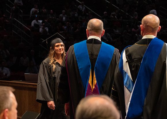 Students graduate and walk to receive their diplomas during convocation in the College of Physical Sciences and Engineering.