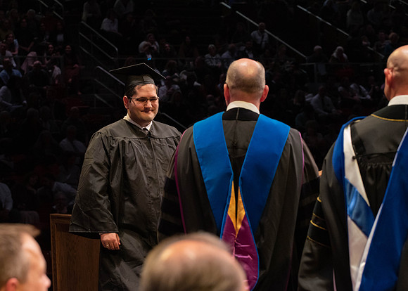 Students graduate and walk to receive their diplomas during convocation in the College of Physical Sciences and Engineering.