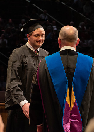 Students graduate and walk to receive their diplomas during convocation in the College of Physical Sciences and Engineering.