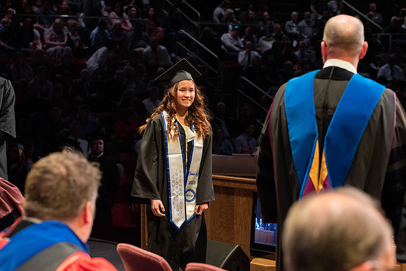 Students graduate and walk to receive their diplomas during convocation in the College of Physical Sciences and Engineering.