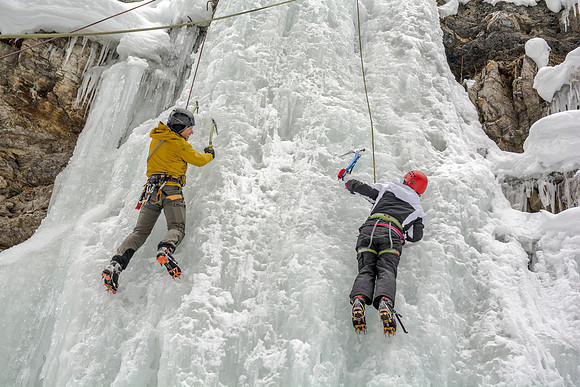 Scott Hurst (left) helping Megan Asplund (right) ice climbing.