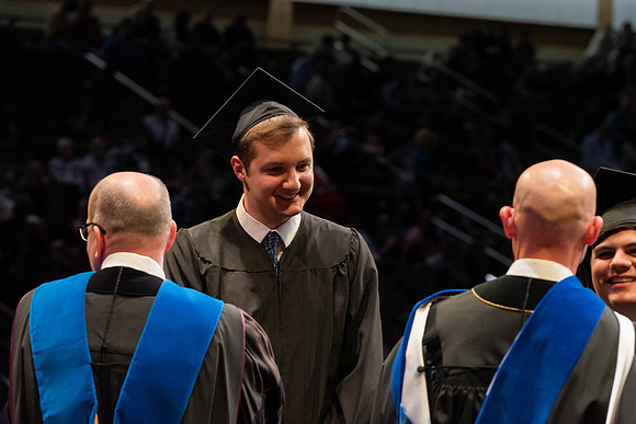 Students graduate and walk to receive their diplomas during convocation in the College of Physical Sciences and Engineering.