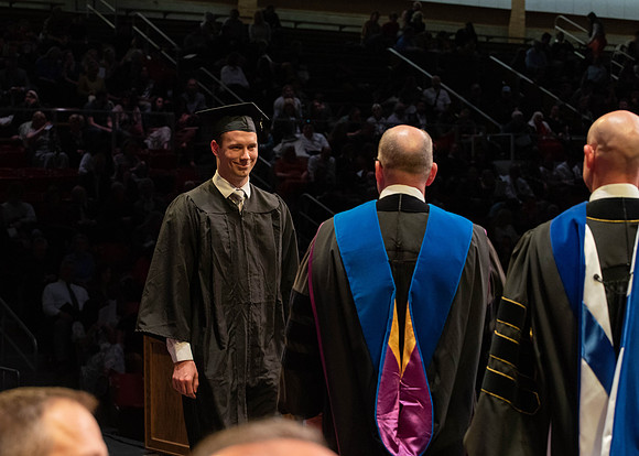 Students graduate and walk to receive their diplomas during convocation in the College of Physical Sciences and Engineering.