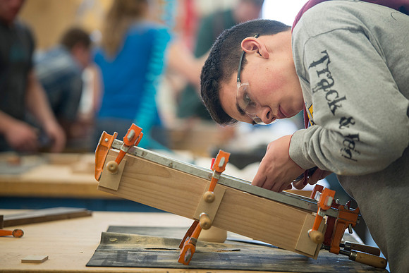 Students work on their semester long project of building a clock during class.