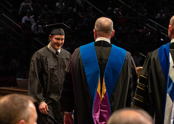 Students graduate and walk to receive their diplomas during convocation in the College of Physical Sciences and Engineering.