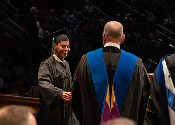 Students graduate and walk to receive their diplomas during convocation in the College of Physical Sciences and Engineering.