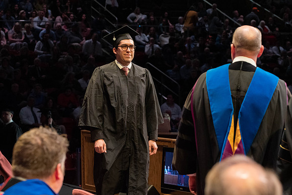 Students graduate and walk to receive their diplomas during convocation in the College of Physical Sciences and Engineering.