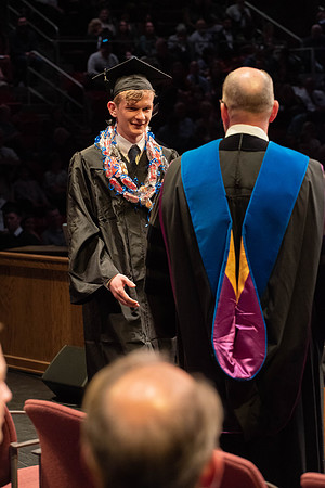 Students graduate and walk to receive their diplomas during convocation in the College of Physical Sciences and Engineering.