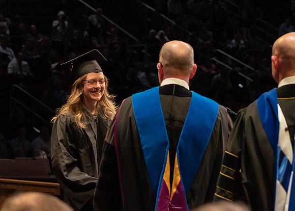 Students graduate and walk to receive their diplomas during convocation in the College of Physical Sciences and Engineering.