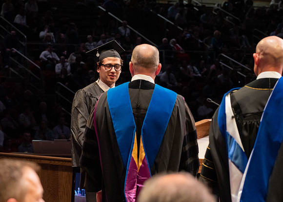Students graduate and walk to receive their diplomas during convocation in the College of Physical Sciences and Engineering.