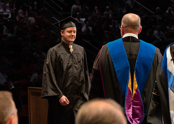 Students graduate and walk to receive their diplomas during convocation in the College of Physical Sciences and Engineering.