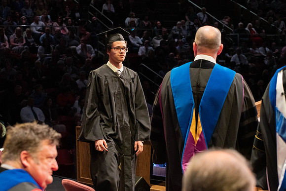 Students graduate and walk to receive their diplomas during convocation in the College of Physical Sciences and Engineering.