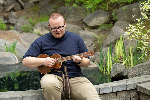 Thommy Oaks enjoying a little freetime in the gardens while playing the ukulele.