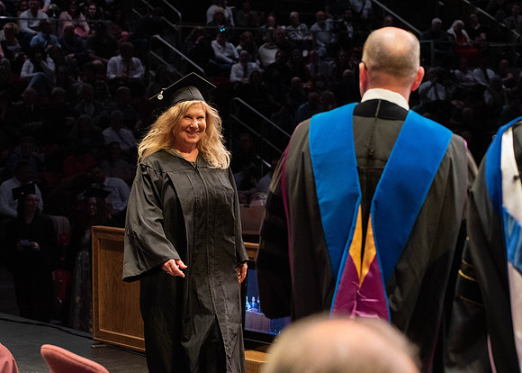 Students graduate and walk to receive their diplomas during convocation in the College of Physical Sciences and Engineering.