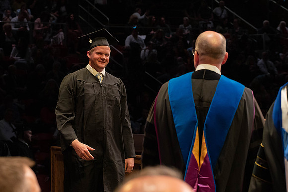 Students graduate and walk to receive their diplomas during convocation in the College of Physical Sciences and Engineering.