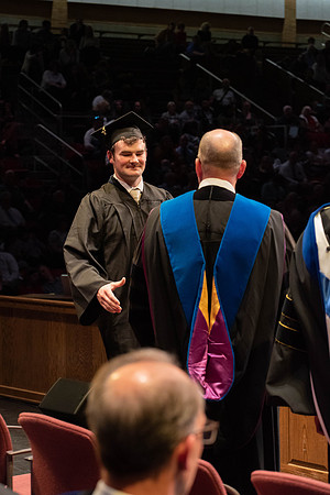 Students graduate and walk to receive their diplomas during convocation in the College of Physical Sciences and Engineering.