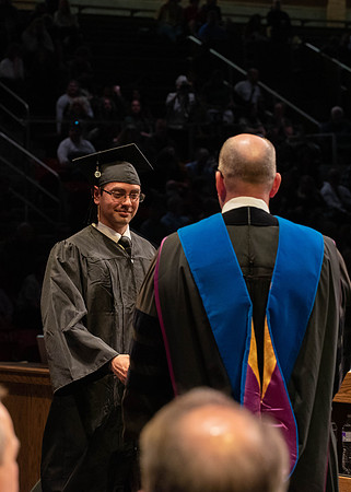 Students graduate and walk to receive their diplomas during convocation in the College of Physical Sciences and Engineering.