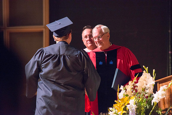 Elder Robert C. Gay of the First Quorum of the Seventy along with President Kim B. Clark and John Linford, Dean of the College of Foundations and Interdisciplinary Studies, present the graduates with