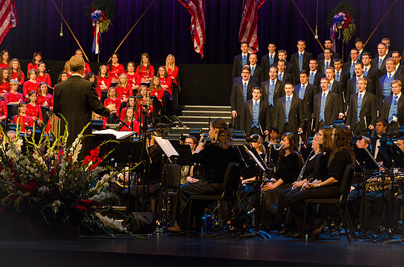 Members of the Collegiate Singers, Men's Choir, Women's Choir, and Symphony Band all perform together at the Patriots and Pioneers Concert.