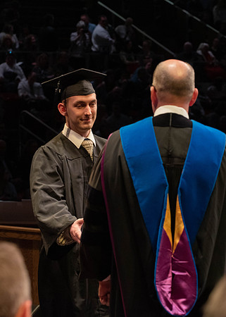 Students graduate and walk to receive their diplomas during convocation in the College of Physical Sciences and Engineering.