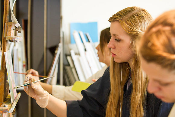 A student in Brother Bodily's Painting class begins to paint a beautiful landcape in the Spori Building.