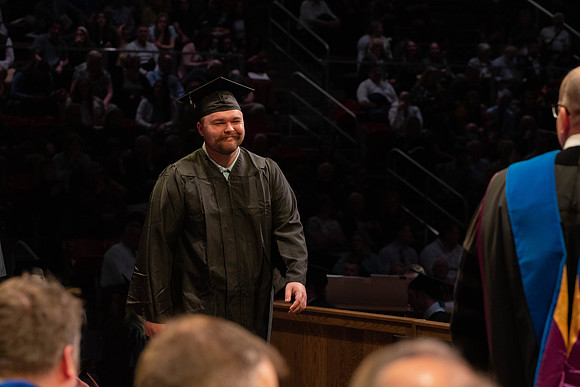 Students graduate and walk to receive their diplomas during convocation in the College of Physical Sciences and Engineering.