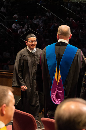 Students graduate and walk to receive their diplomas during convocation in the College of Physical Sciences and Engineering.