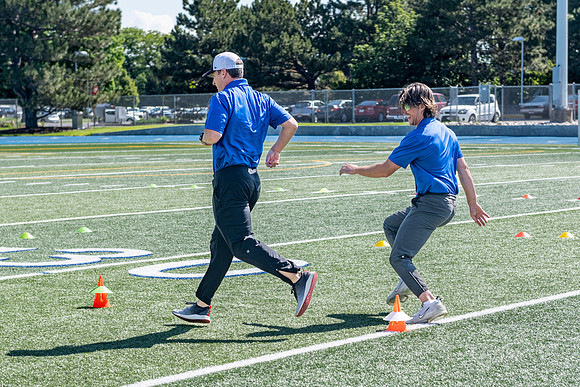 Coaches teach younger kids ages 12-16 exercise drills on the BYU-Idaho stadium field at a speed and agility camp.
