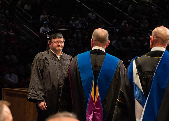 Students graduate and walk to receive their diplomas during convocation in the College of Physical Sciences and Engineering.