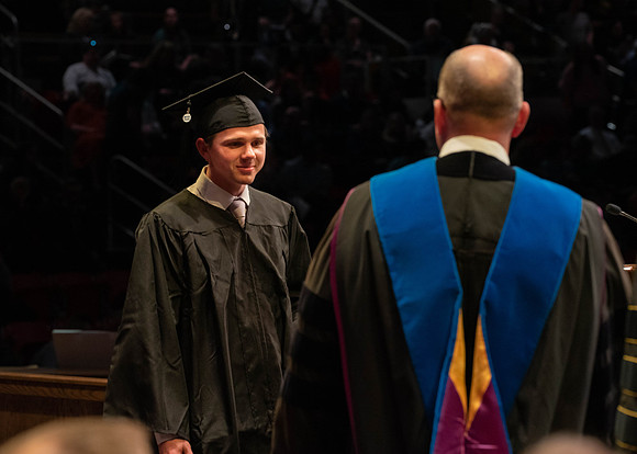 Students graduate and walk to receive their diplomas during convocation in the College of Physical Sciences and Engineering.